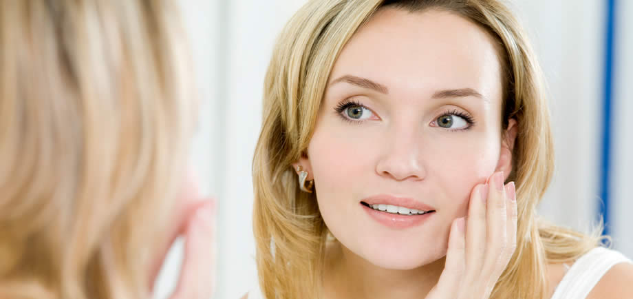 Woman with smooth skin looking in mirror