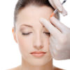giving an injection in the eyebrow on the female face - white background