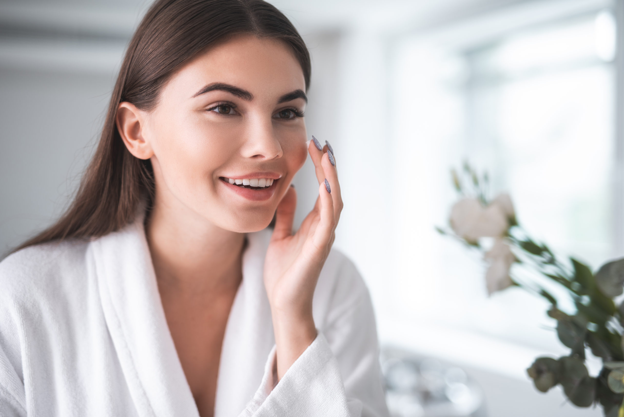 Young girl doing face treatment in morning